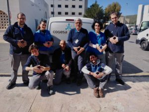 Trabajadores de Cogesa posan en las cocheras haciendo el símbolo RED de FEDER por las enfermedades raras